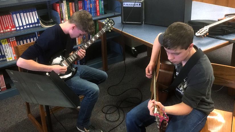 Two High school students playing guitars