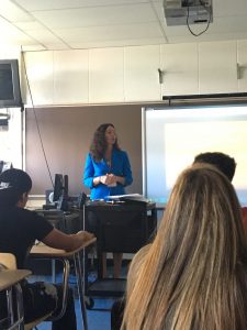 woman stands at front of classroom