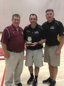 three men, center holding award