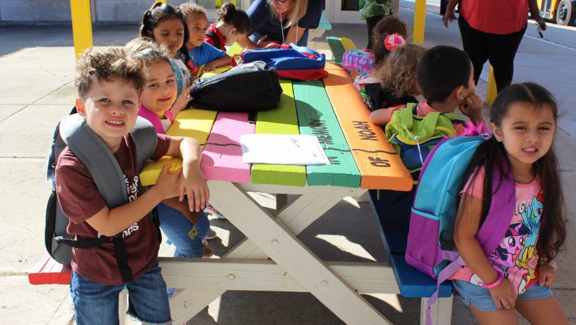 Project excel pre-school students seated at a picnic table