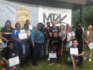 Group of students in front of a banner showing MBK 