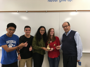 Four Monticello High School students receive their new gavel from a man in glasses, blue shirt and blue vest.