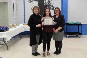 Sage Evans poses between the Monticello Superintendent of Schools and Board of Education president with the Scholar Athlete certificate that she received during the January Board Awards ceremony 