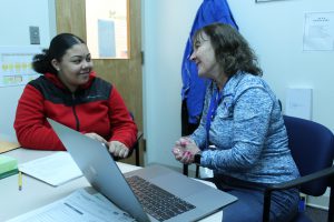 Eighth-grade student TyLia Huise sits with Guidance Counselor Karen Warden at a desk with a computer.