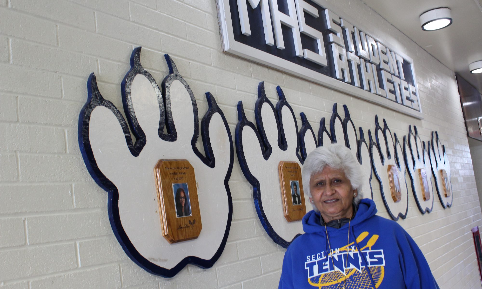Urvashi Gupta stands in the hallway of Monticello High School with plaques behind her on the wall