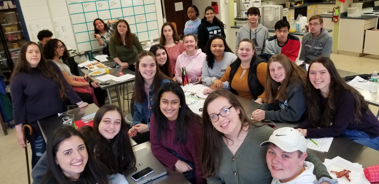 a group of high school students pose while eating breakfast