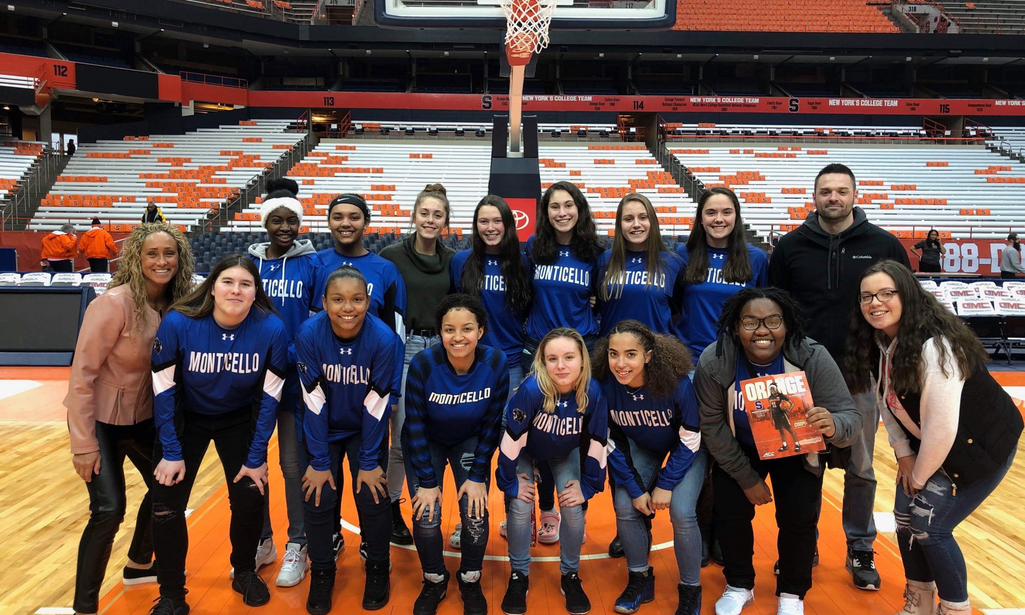 The Monticello High School girls basketball team stands center court at Syracuse