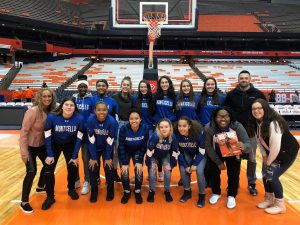 The Monticello High School girls basketball team stands center court at Syracuse