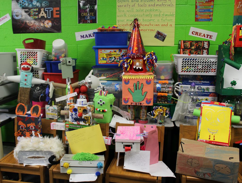 A large group of homemade monsters, some with party hats, bright green, hands out wide.