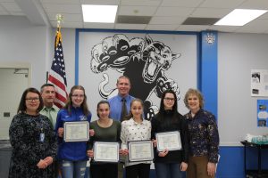 The girls indoor track team holds their Scholar Athlete certificates 