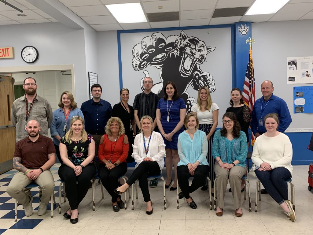 A group of Monticello employees who have just received tenure pose in the cafeteria 