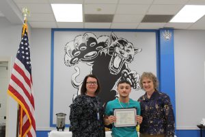 Isaac Hernandez poses with his scholar athlete certificate 