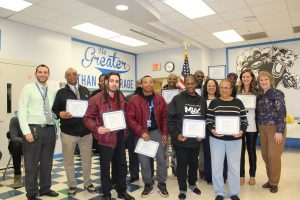 Member of the My Brother's Keeper team pose, holding their Board Award certificates 