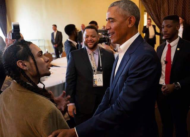 A young may shakes hands with President Barack Obama.