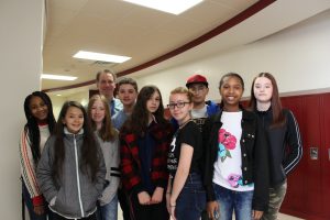 Gary Silverman stands in the hallway of the Robert J. Kaiser Middle School surrounded by students 