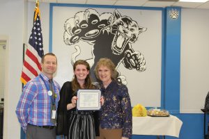 Sofia Heimowitz stands holding her certificate at the Board Awards ceremony 