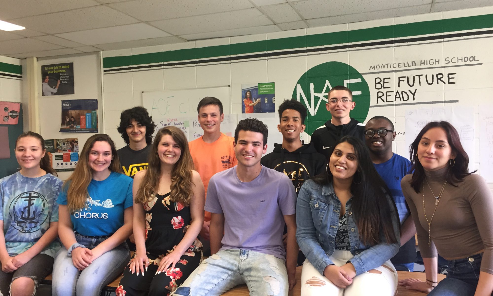 the academy of finance students sit on a table