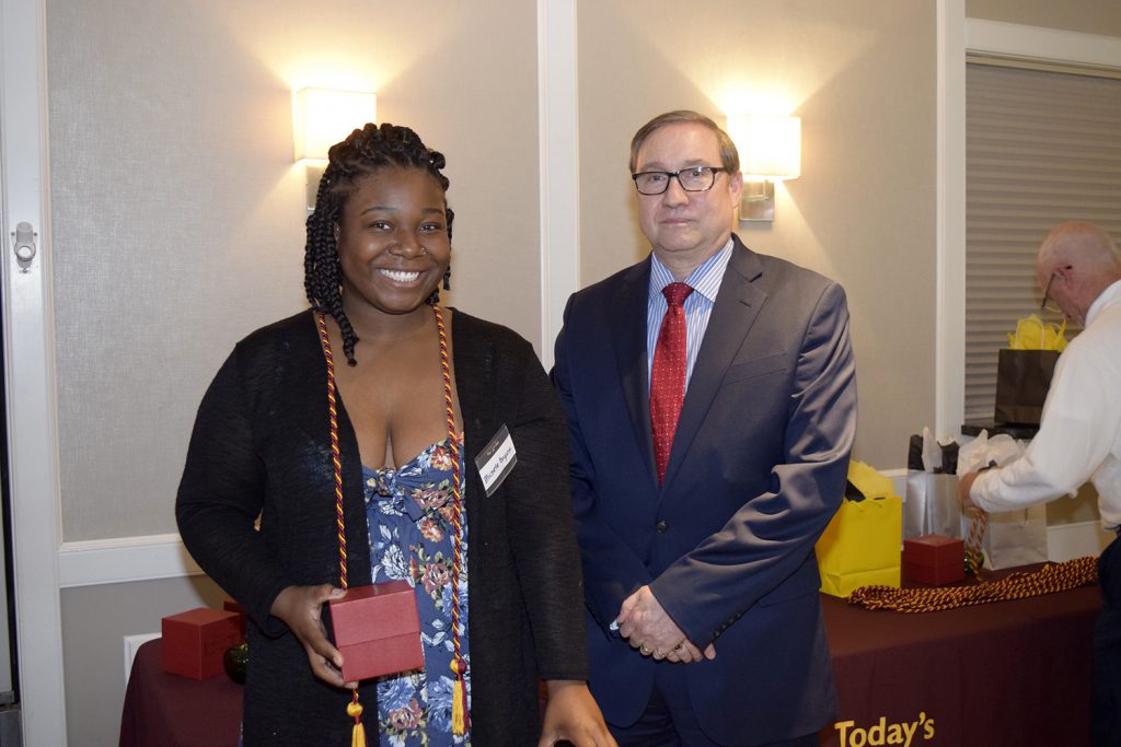 Young woman smiling next to a man in a suite