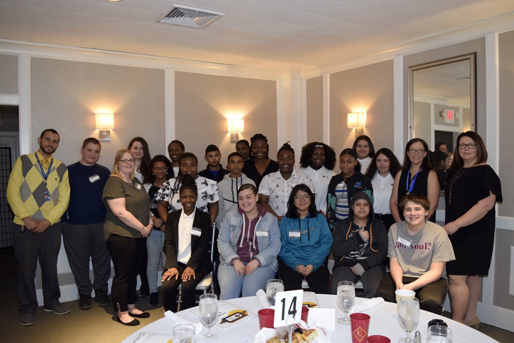 Large group of students and teachers sitting and standing in a banquet room