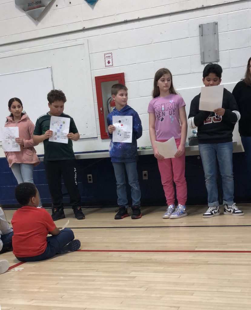 A line of elementary students hold their awards