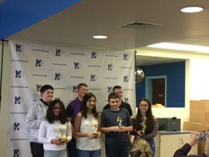 the students of distinction stand and hold trophies 