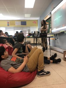 Linda Seminario stands in front of group of seated students 