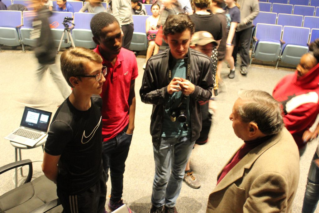 Three young men gather to talk with an elderly man