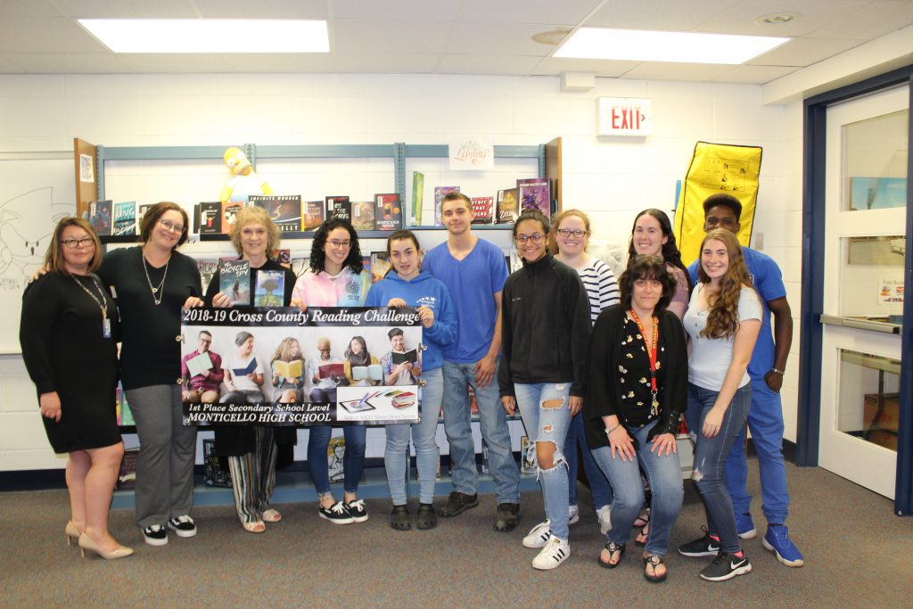 a group of Monticello High School students pose with a banner and with adults