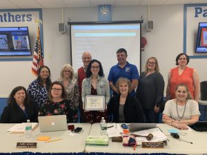 Molly Garcia stands in the center of the Board of Education and administrative team