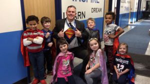 Assistant Principal Doug Murphy is surrounded by children in a hallway 