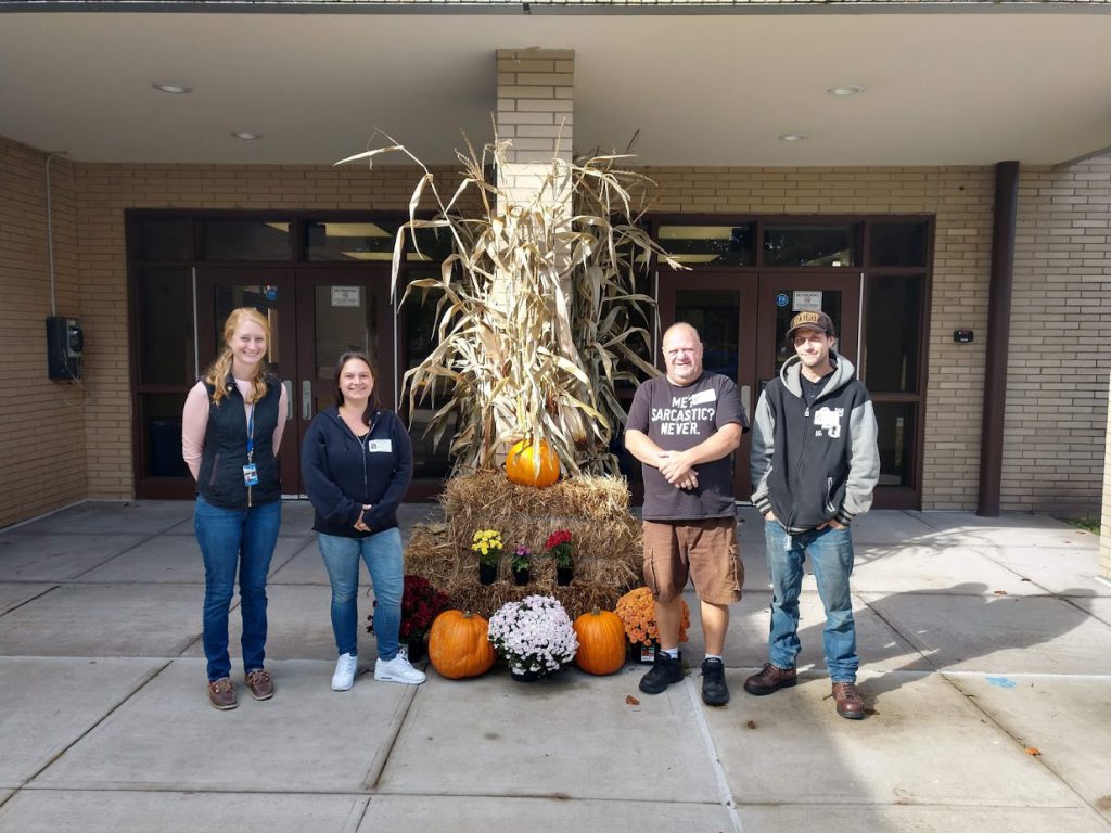 four people are standing in front of the Chase Elementary School Buildinf 