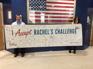 jessi-ann rosenbaum holds a banner with nick millas 