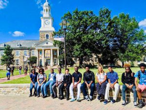a group of students sit outside of a college
