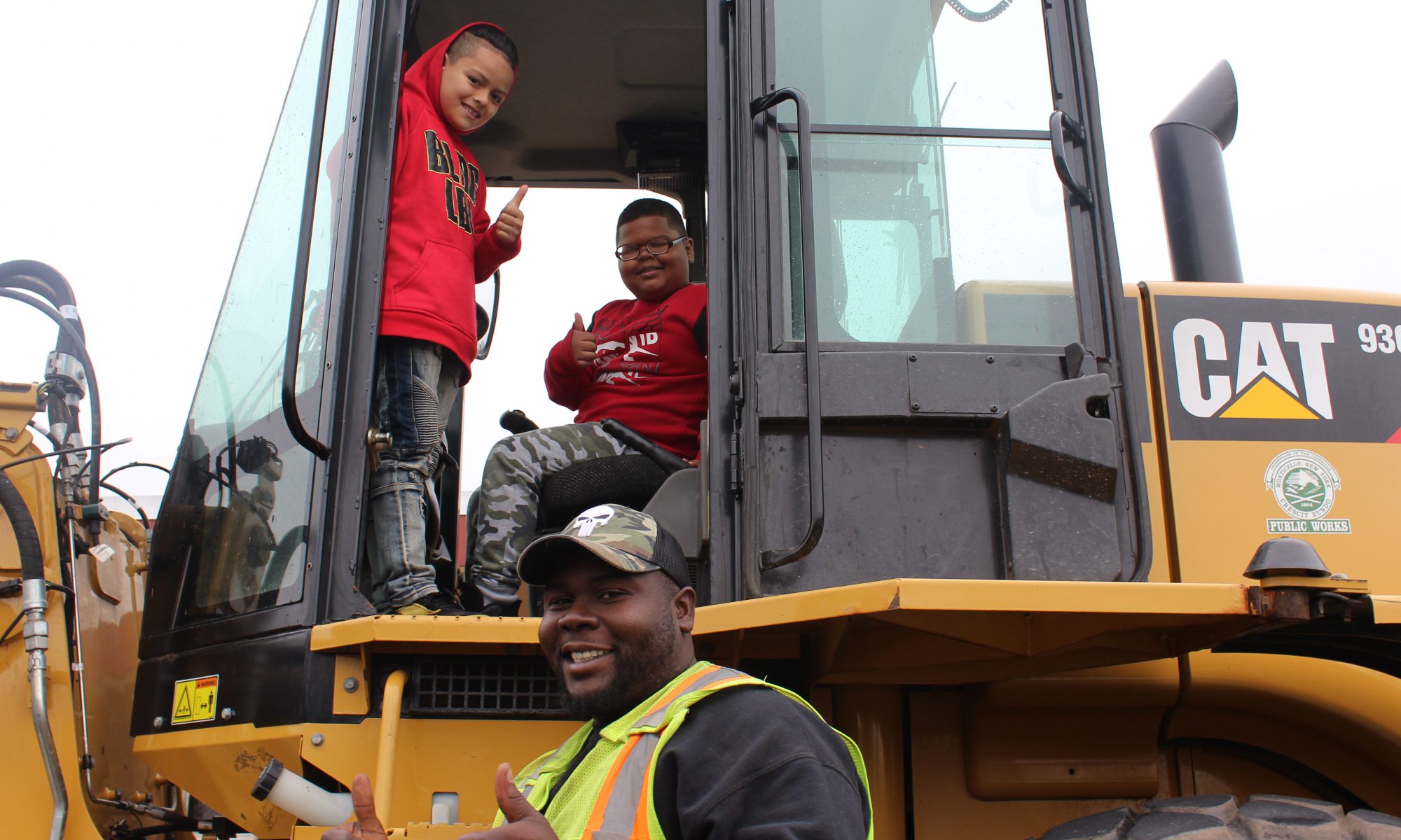 two students pose on a bulldozer