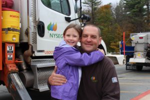 a student hugs her Dad in front of his truck 