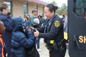 Deputy Rose Ionta helps a student try on a Sherrif's vest.