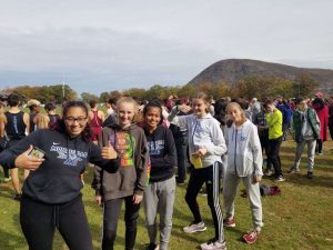 members of the girls cross country team smile before they race 