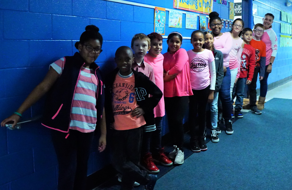 a group of students wear pink