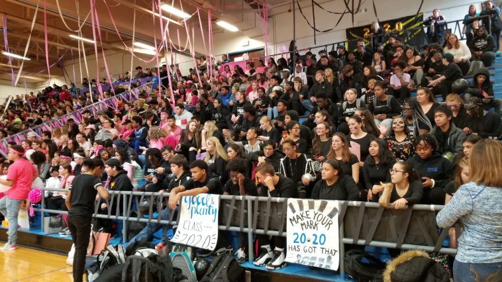A large group of students sit in the bleachers during the pep rally