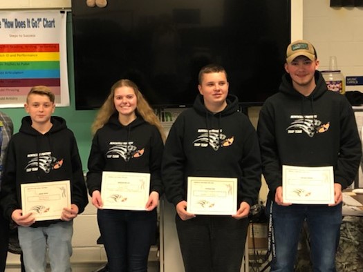 four members of the trap team pose with awards