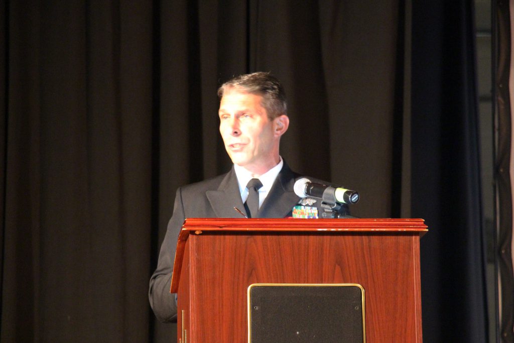 A man in uniform speaks at a podium