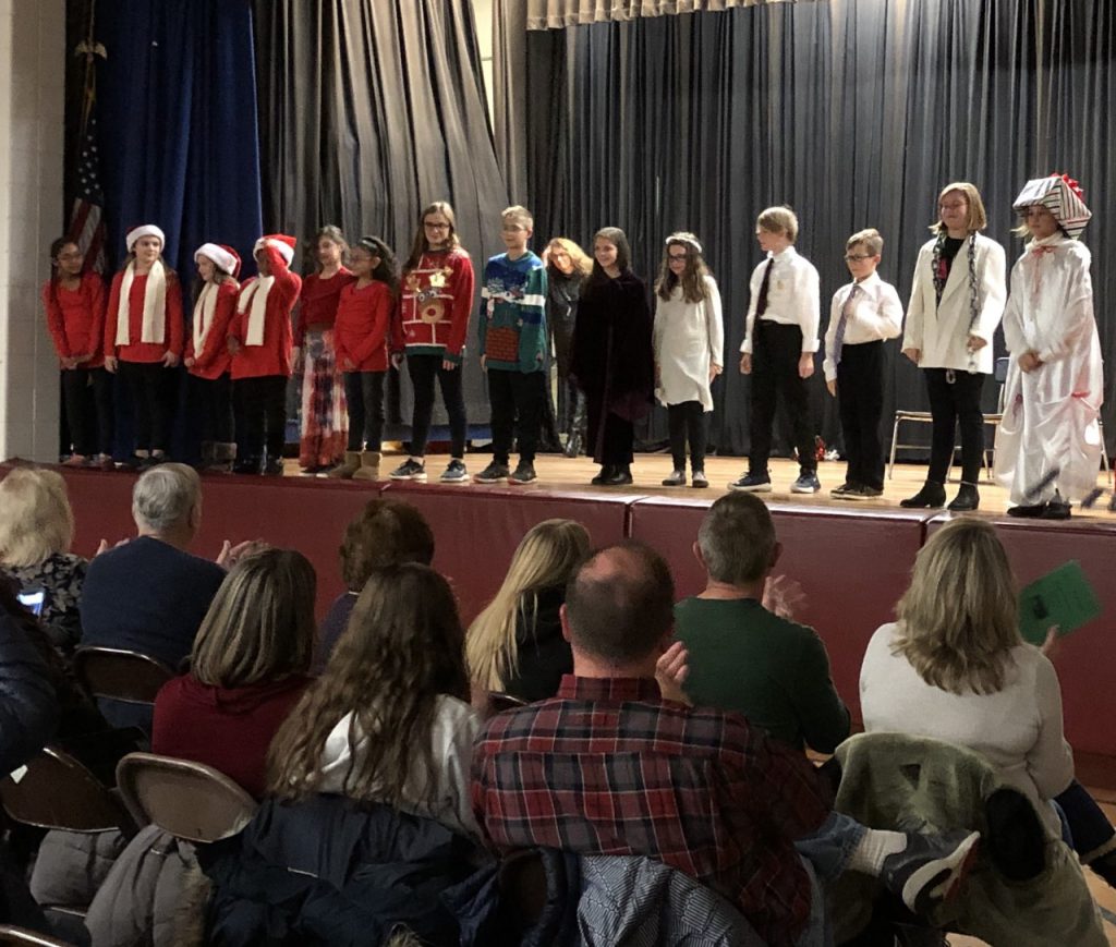 students in the play are taking bows on stage 