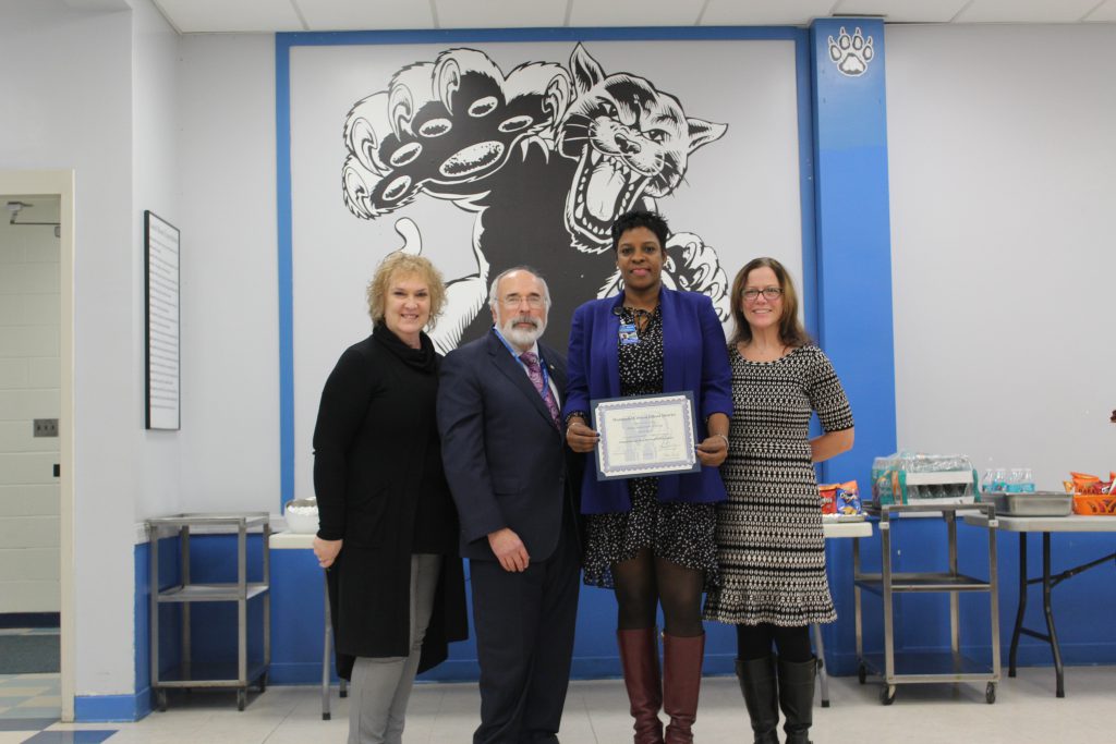 Rachel Blount stands with colleagues and holds certificate