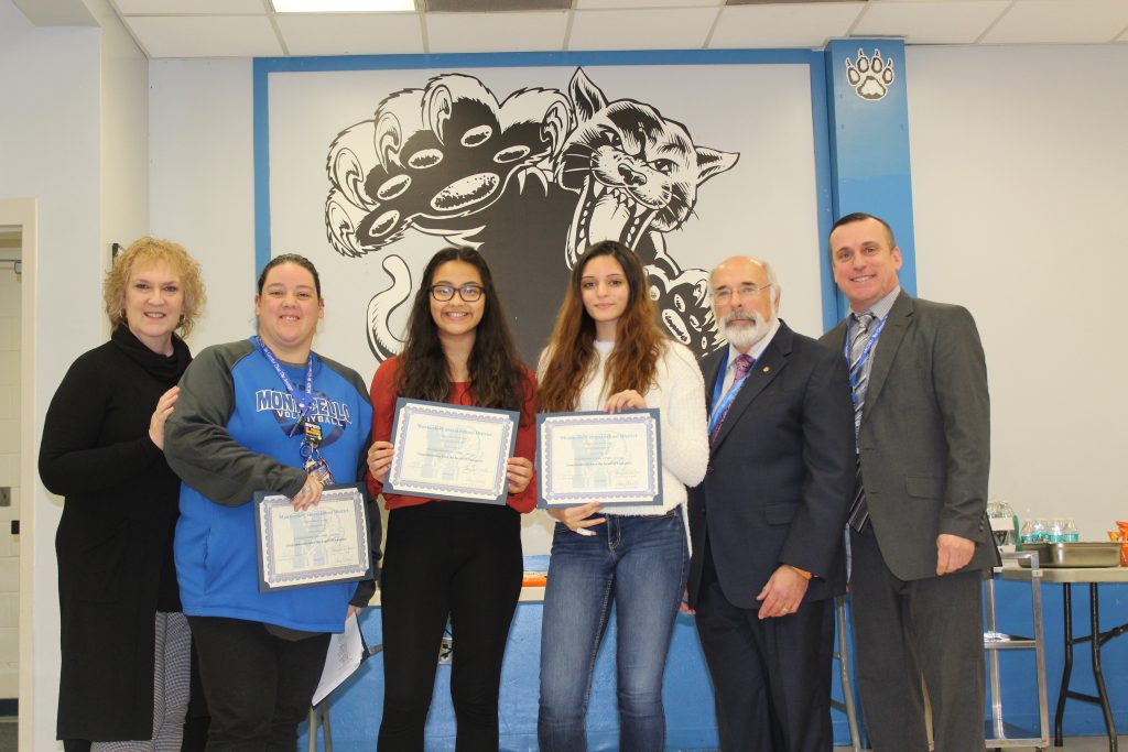 Members of the girls volleyball team are standing and holding their certificates