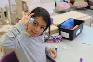 a student holds a paper chain link up to the camera 