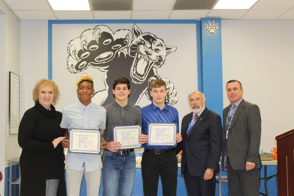 members of the boys soccer team are standing and smiling 