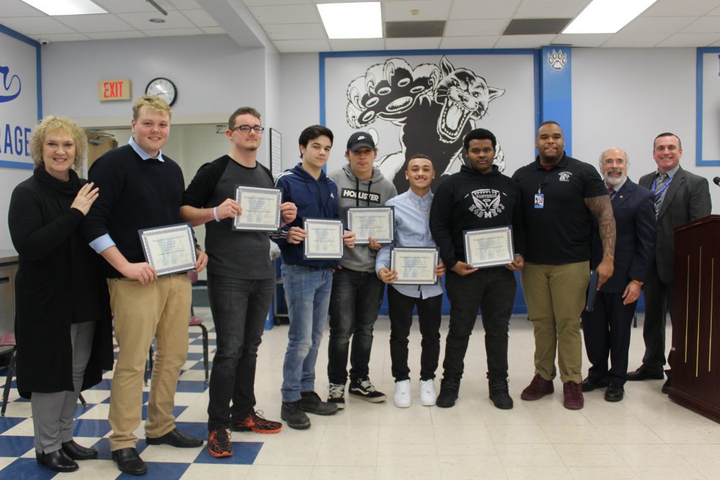 members of the boys football team are standing and holding their certificates 