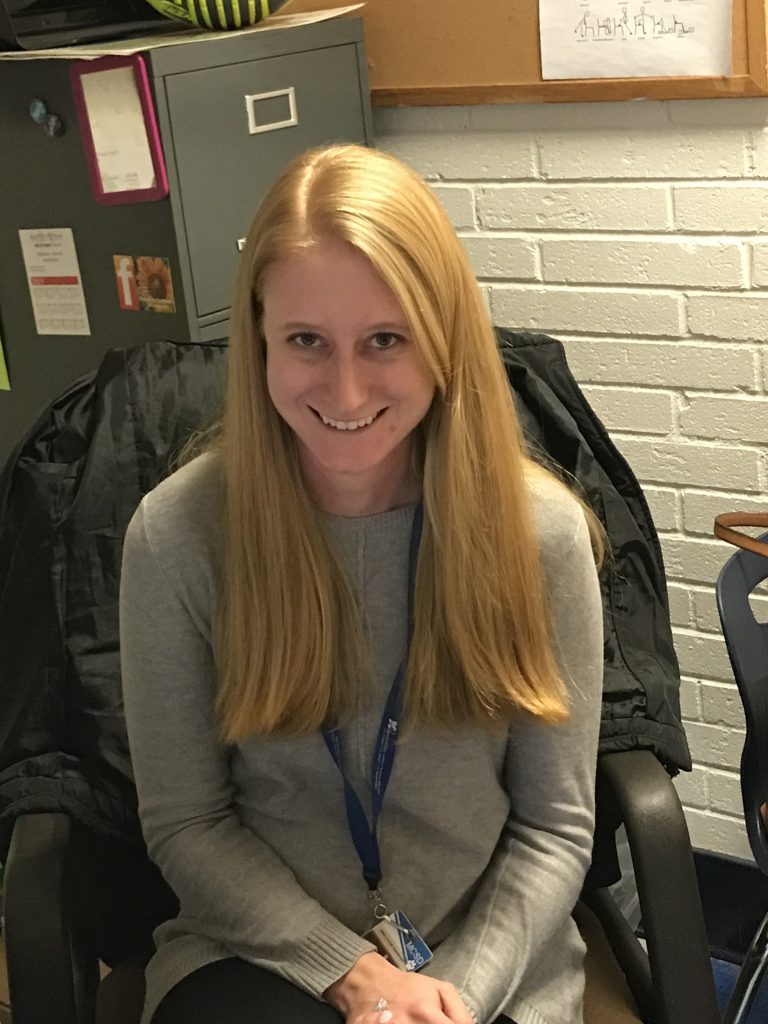 Katie Rubin smiles at her desk 