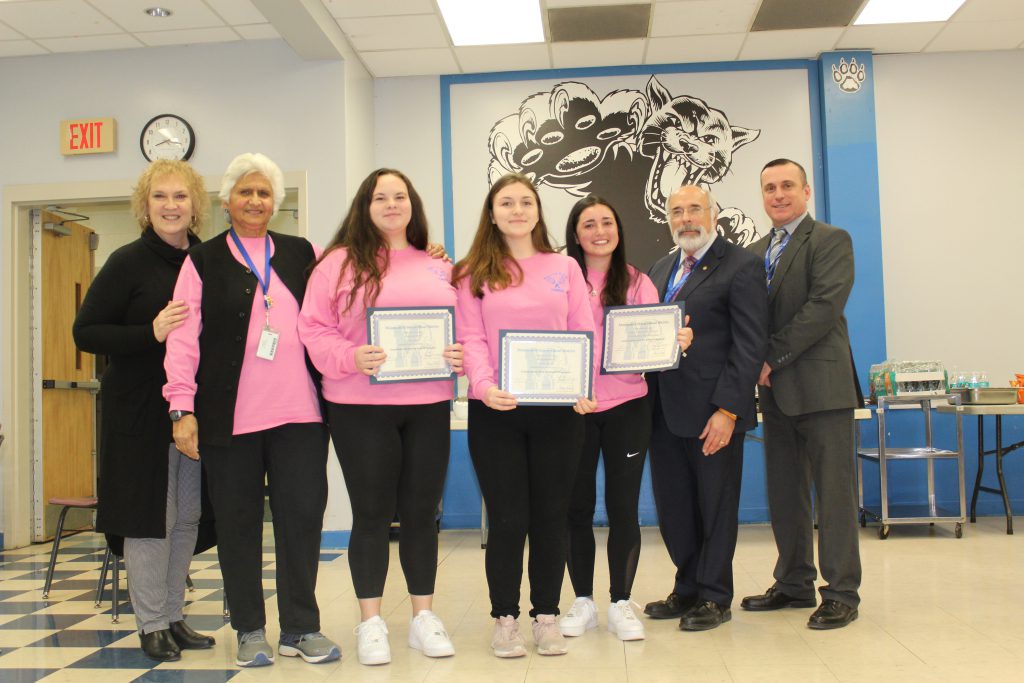 members of the girls tennis team stand and hold their certificates 