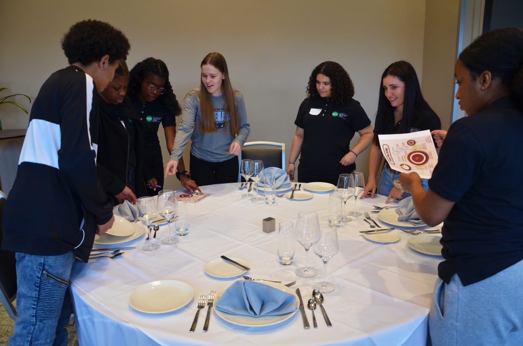 students are standing around a table 